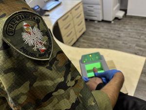 Funkcjonariusze z Placówki Straży Granicznej w Braniewie pobierają odciski palców linii papilarnych od cudzoziemca Funkcjonariusze z Placówki Straży Granicznej w Braniewie pobierają odciski palców linii papilarnych od cudzoziemca